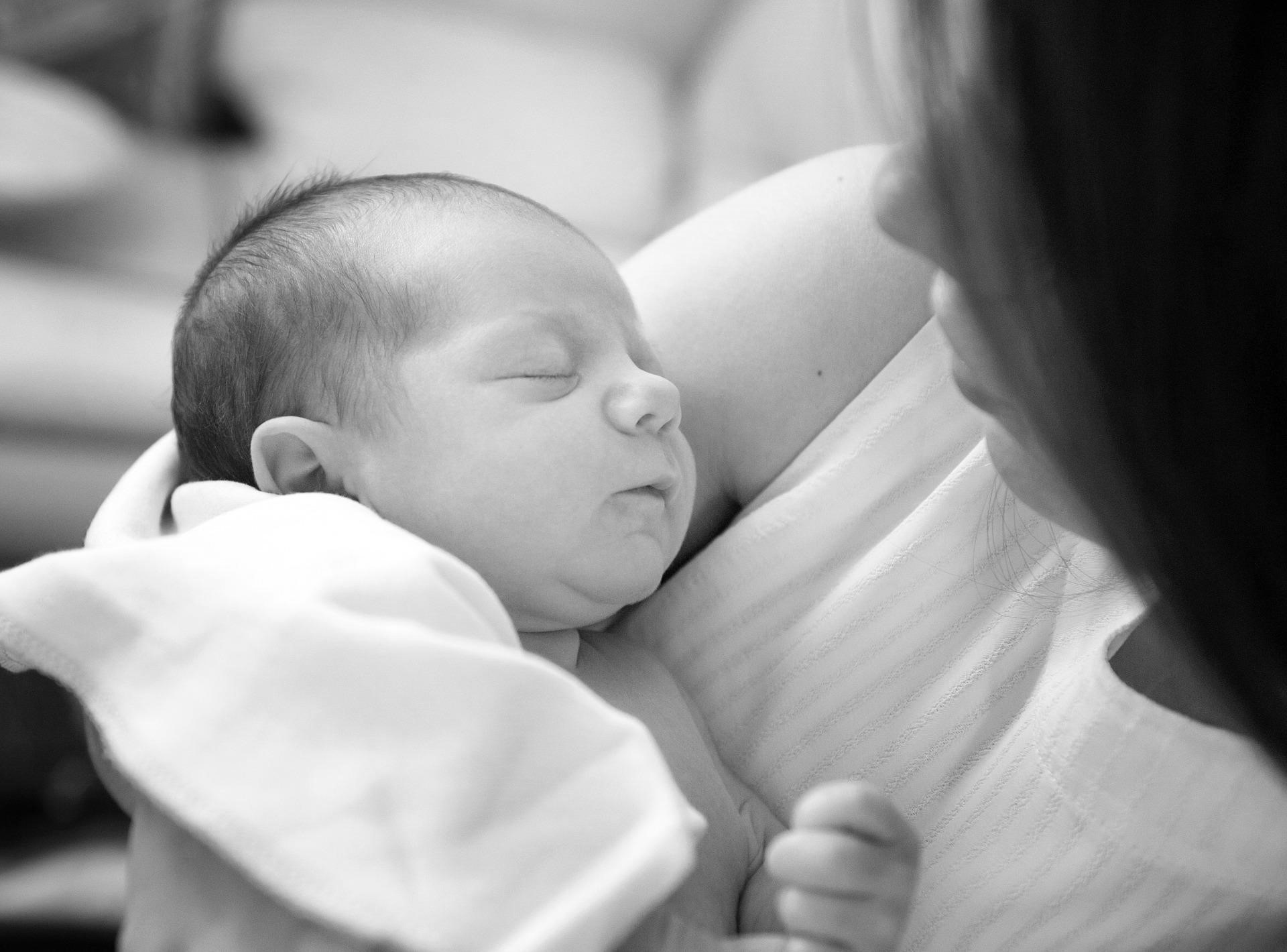 bébé dort paisiblement dans les bars de sa maman